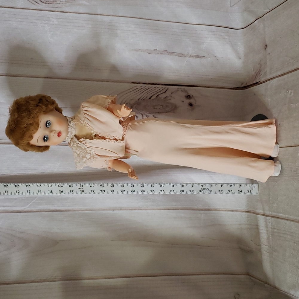 Vintage Doll 24 inches tall. Dressed in silk outfit. Comes with stand.